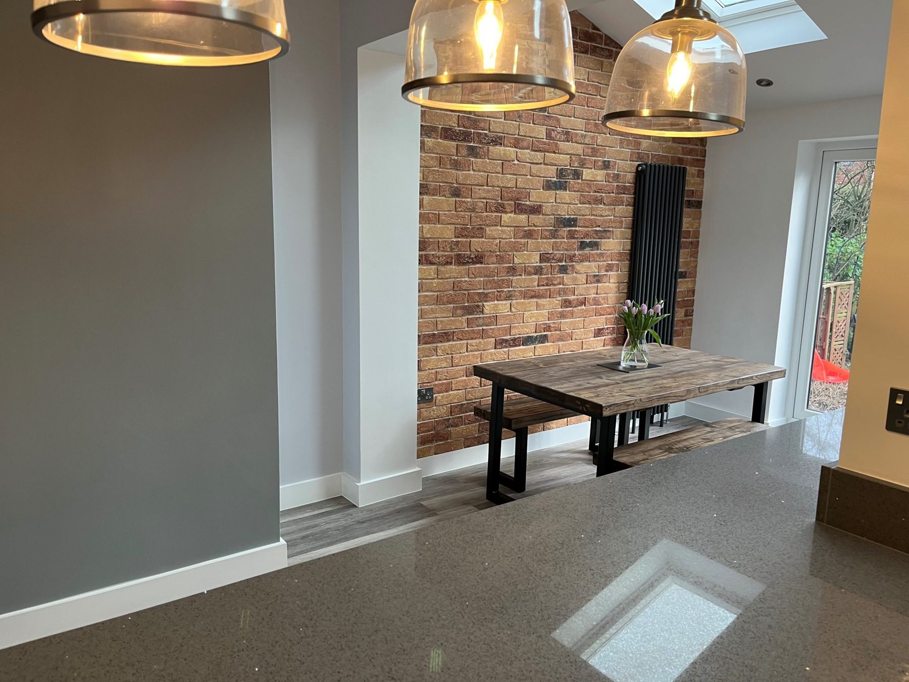 Finished open-plan interior with exposed brick wall and pendant lighting